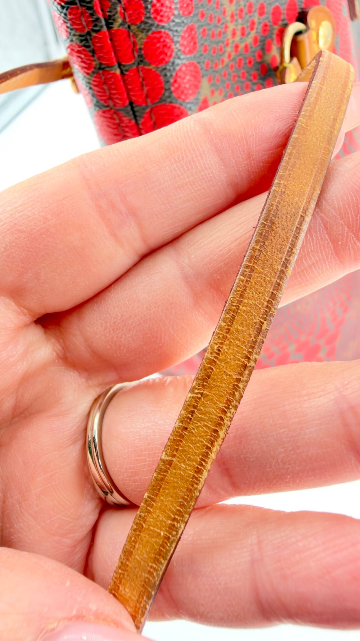 Kusama Neverfull vachetta handle edge close-up showing patina