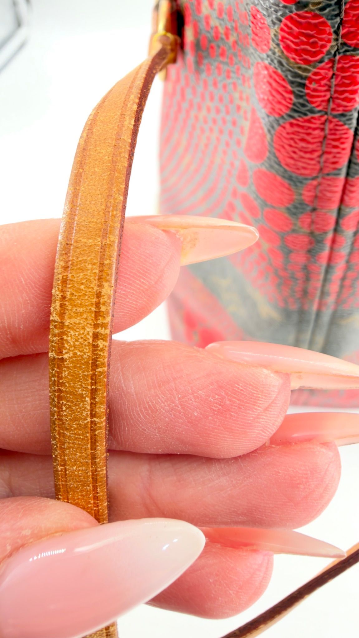 Kusama Neverfull vachetta side cinch strap close-up
