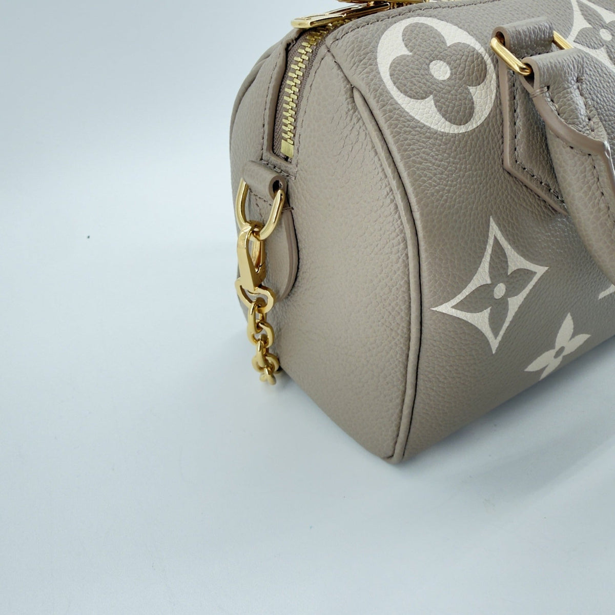 Side detail of Speedy Bandoulière 20 zip closure and gold chain strap hardware