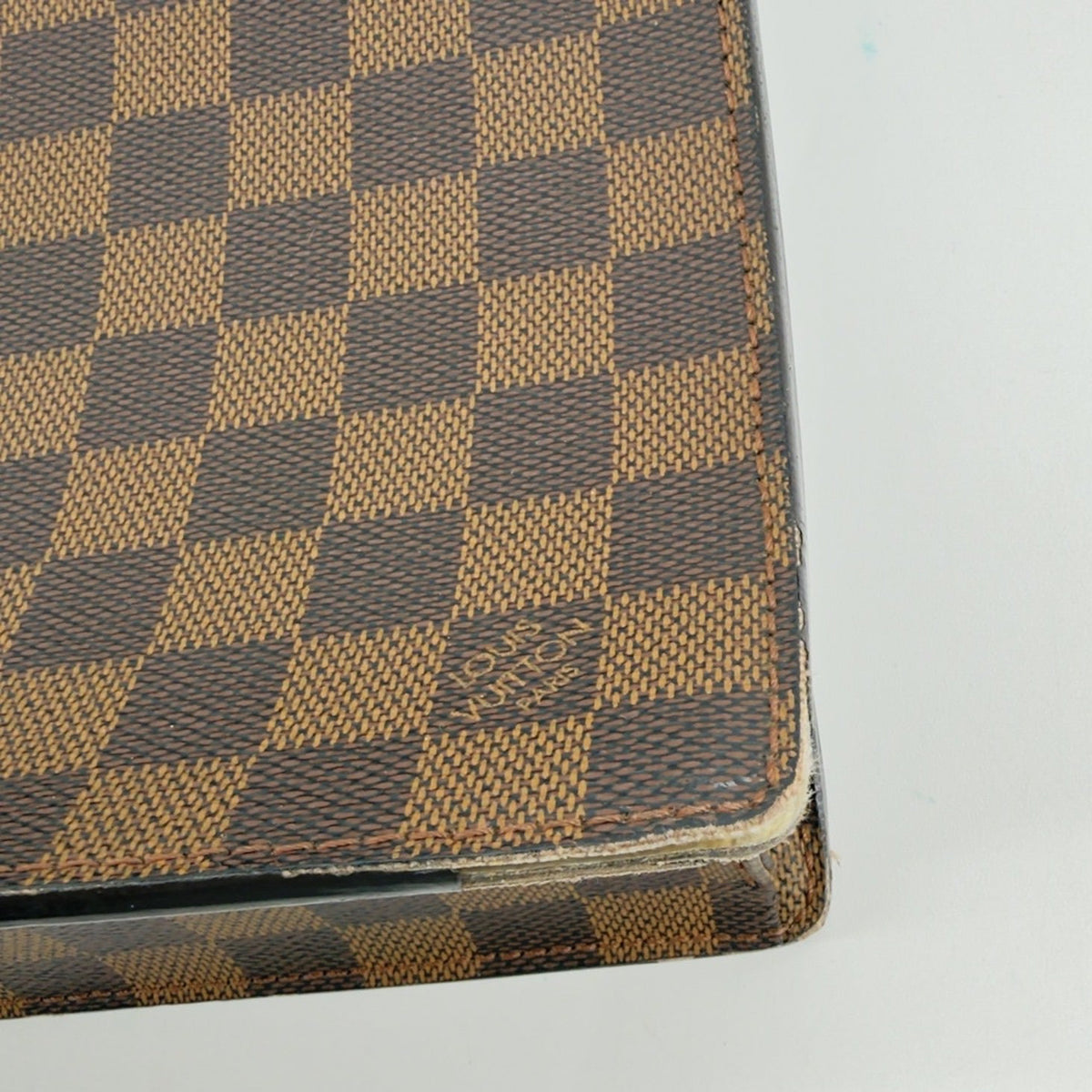 Close-up detail of corner wear on Damier Ebene Serviette Conseiller briefcase