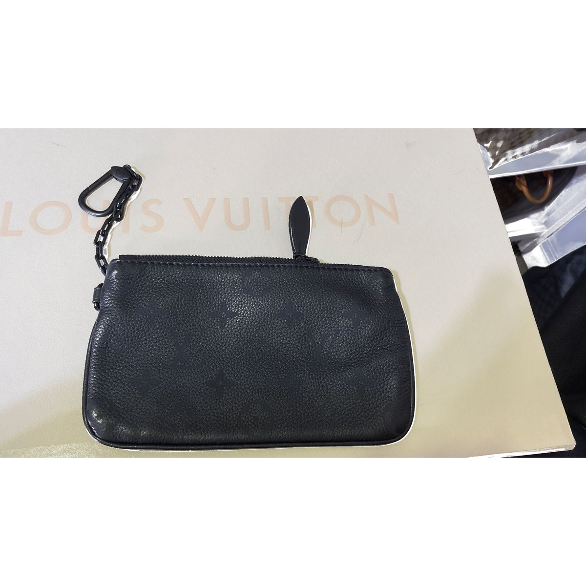 Matching black tonal-monogram zip pouch with chain on Louis Vuitton shopping bag